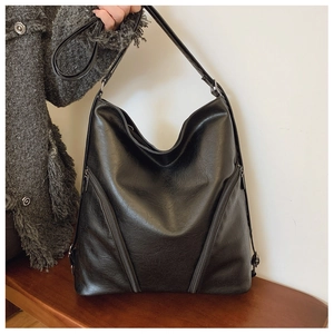 Detail of soft black synthetic leather texture on a large capacity shoulder tote bag