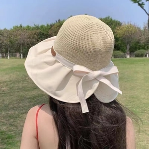 Women's summer straw sun hat with large brim, beige weave, and elegant bow decoration