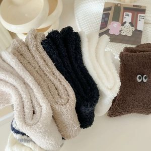 Macro detail of thick coral fleece socks with cute cartoon eye embroidery for winter