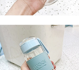 Detail of light blue leather sleeve with LUOQI embossing on portable glass water bottle