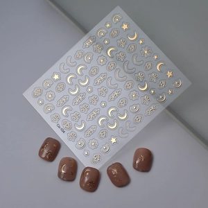 Gold star and moon nail stickers with pink manicure application on grey background