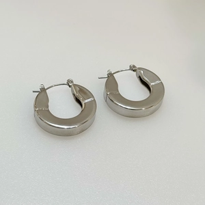 Detailed view of polished thick silver horseshoe hoop earrings on a white background