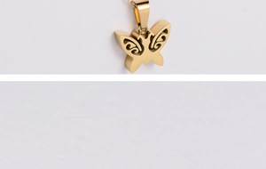 Close-up of a polished golden butterfly pendant with a hollow double-layer metal design
