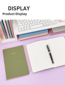 Close-up of minimalist A5 leather notebook with gold embossed logo and business pen