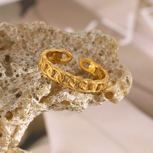 Detailed macro shot of 18K gold plated stainless steel chain link open ring on stone