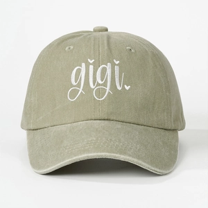 Close-up of olive washed cotton baseball cap with white gigi embroidery and heart detail