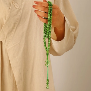 Close-up of Islamic Tasbih 99 beads in green stone finish with moon star pendant detail