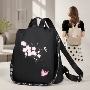 Detail der Blumenstickerei auf wasserfestem schwarzem Nylonrucksack mit Tragegriff