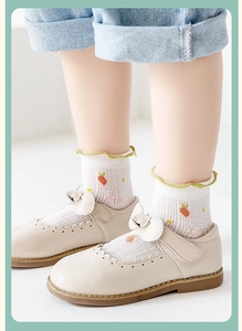 Close-up of breathable mesh socks with strawberry pattern and white Mary Jane shoes