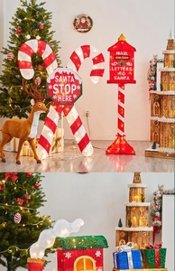 Close-up of lighted red Christmas mailbox with festive candy cane and LED holiday decor