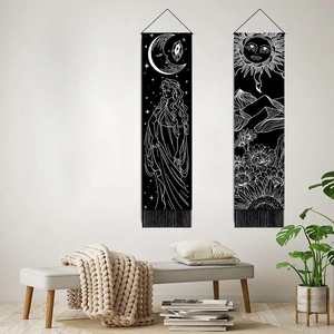Bohemian black tapestries with moon and sun line art patterns and tassels on a wall