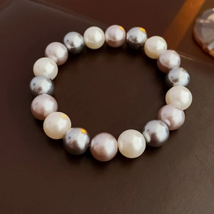 Macro shot of multi-colored pearl bracelet with white grey and pink tones on leather