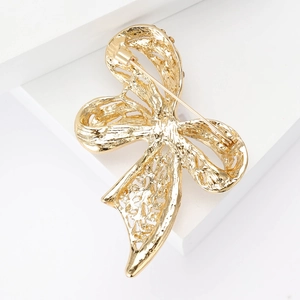 Golden bow-shaped brooch with vintage pearl detail and elegant hollow design on white base