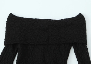 Détail de l'encolure bustier et des manches en dentelle sur une robe noire moulante