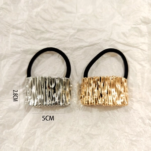 Detail of silver and gold textured metal hair ties with 2.8cm x 5cm dimension labels