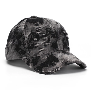 Detailed view of vintage distressed denim baseball cap with camouflage pattern and rips