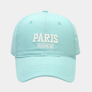 Detail of white PARIS FRENCH embroidery on mint blue cotton baseball cap surface