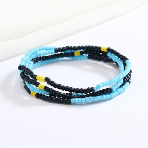 Detailed view of handmade sky blue, black, and yellow seed bead elastic waist chain layers
