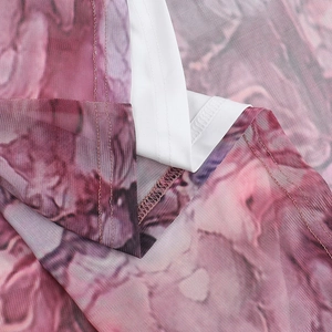 Détail du tissu en maille imprimé marbre rose avec couture surjet blanche de qualité