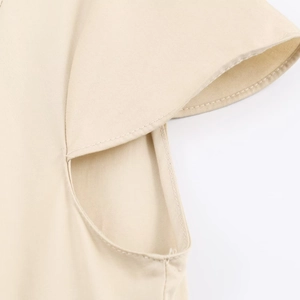 Detailed macro view of apricot midi dress sleeve seam with high-quality twill fabric texture