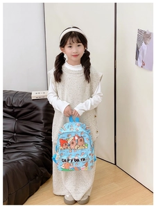 Toddler wearing a light blue capybara print backpack in a cozy indoor setting
