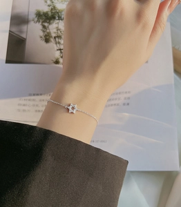 Detailed view of silver star bracelet with sparkling zircon stones on a model wrist