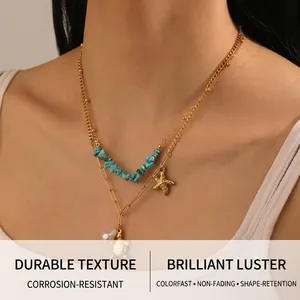 Close-up of double layer gold necklace with turtle, starfish and turquoise stone