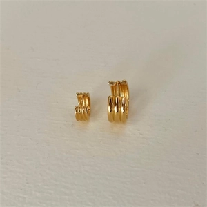 Detailed view of layered gold-plated hoop earrings with three-tier textured stripes