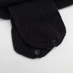 Detail of black knitted earflap hat with secure plastic snaps for winter thermal protection