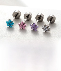 Macro detail of titanium steel star stud earrings set with colorful zircon stones