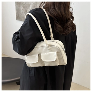 Chic cream white patent leather shoulder bag with two front pockets and sleek design