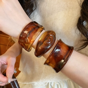 Set of three amber resin bangles with tortoiseshell patterns in diverse geometric shapes
