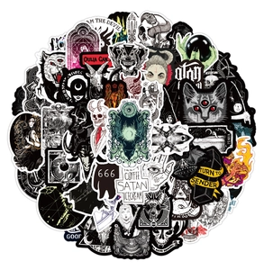 Close-up of gothic punk graffiti stickers featuring dark skulls and satanic motifs