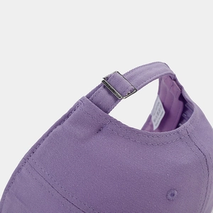 Detail of adjustable metal buckle and cotton fabric on purple baseball cap
