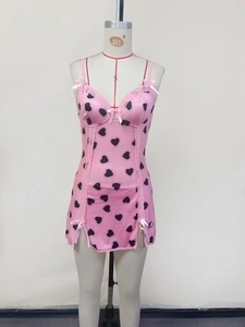 Detailed view of pink heart print dress with lace trim, bow, and side slit design