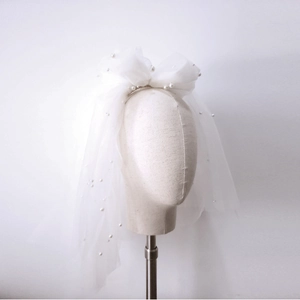 Detail of white double-layered bridal veil with delicate pearls and soft tulle texture