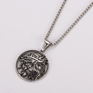 Macro shot of silver stainless steel box chain necklace with Jesus relief pendant