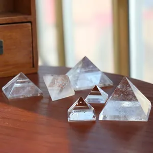 Set of 6 natural clear quartz pyramids in various sizes on a dark wooden surface