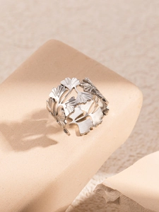 Macro shot of silver titanium ginkgo leaf open ring on minimalist stone display