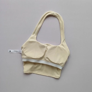 Halter neck sports bra in cream with center ruching and wide elastic white bottom band