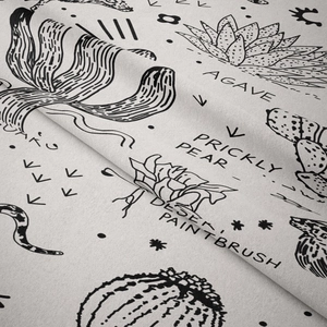 Detailed macro view of black and white desert plant illustrations on fabric tapestry