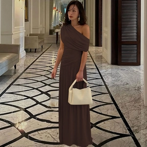 Detail view of the elegant brown pleated fabric and off-shoulder cut on this formal dress