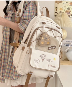 Detail view of cream school backpack with embroidery and small triangle coin pouch