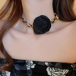 Dettaglio del choker con rosa in seta nera e accenti in metallo dorato sul collo