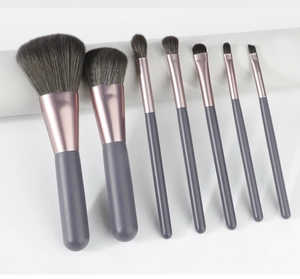 Detail of 7-piece makeup brush set with rose gold ferrules and soft grey bristles