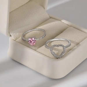 Close-up of S925 sterling silver heart rings with pink zircon in a beige jewelry box