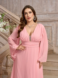 Dettaglio del vestito lungo plissettato rosa con scollo a V, maniche a campana e vita alta