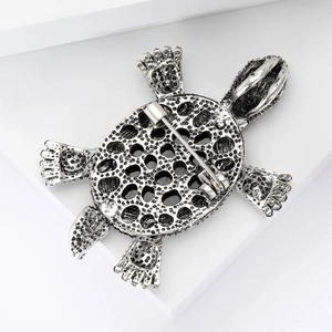 Vintage silver turtle brooch with black enamel texture and detailed metal shell