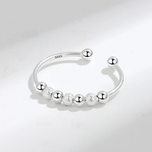 S925 sterling silver anxiety ring with rotating beads on a white marble background