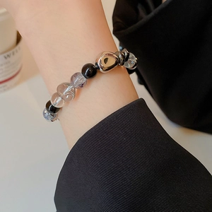 Detail of dark hematite and crystal beaded bracelet on wrist with silver metallic accents